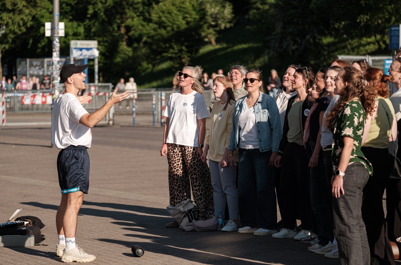 Paula leitet eine Gruppe beim gemeinsamen Singen im Freien an